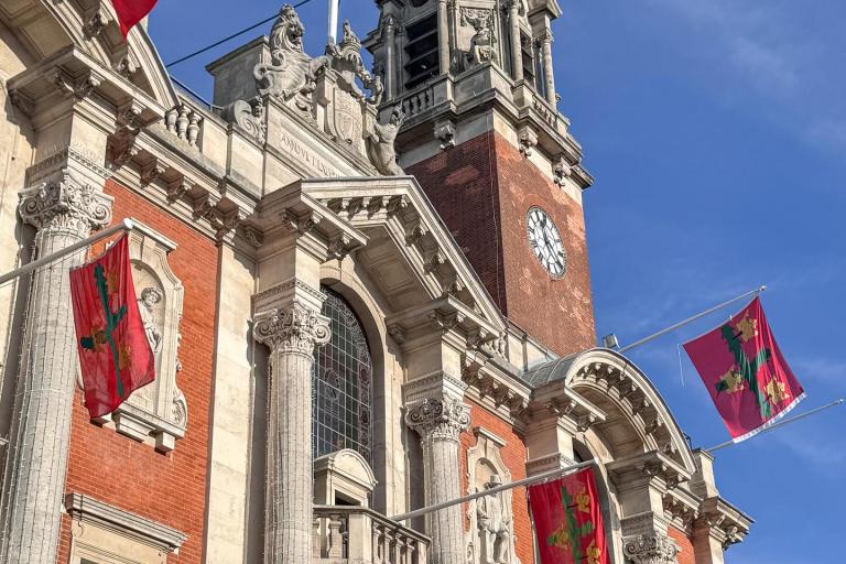 Photo of Colchester Town Hall decorated with red flags for Remembrance Sunday