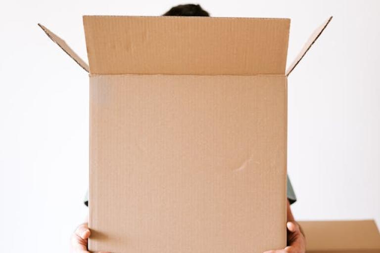Photo of someone holding a box while unpacking in new home