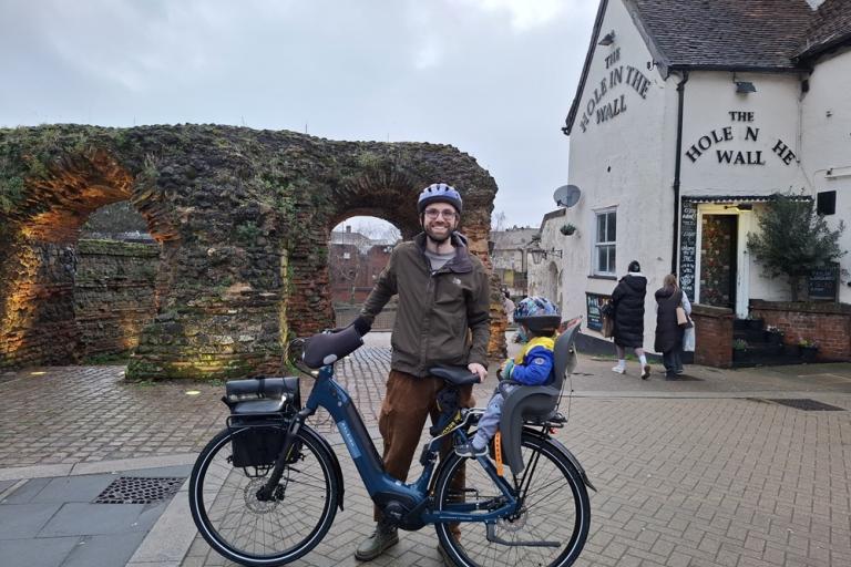 Daniel Stebbings poses with an ebike in front of Balkerne Gate