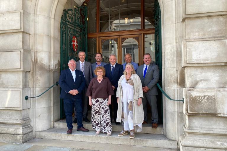 Colchester City Council Cabinet Members standing on the steps of Colchester Town Hall - all smiling