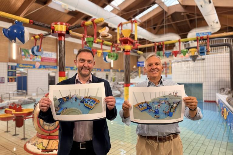 Cllr Goss and Cllr Sunnucks holding plans for new water features at the Leisure Pool