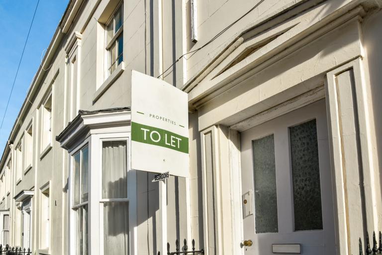 A row of terraced houses with a 'To Let' sign in the foreground
