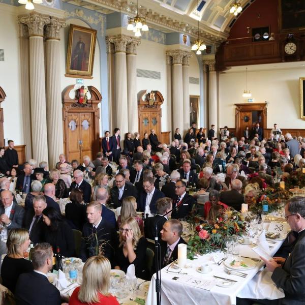 A photo of a large group of people sitting at tables in Colchester City Hall's Moot Hall for the oyster festival
