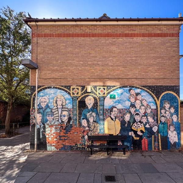 A photo of a mural in Greenstead showing a group of different people on a sunny day