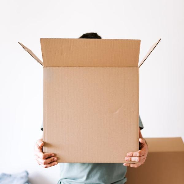 Photo of someone holding a box while unpacking in new home