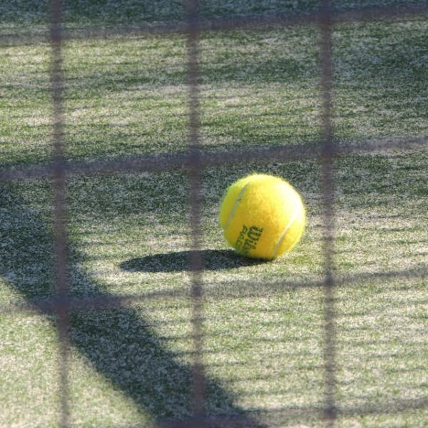 Photo of a tennis ball on the ground of a court