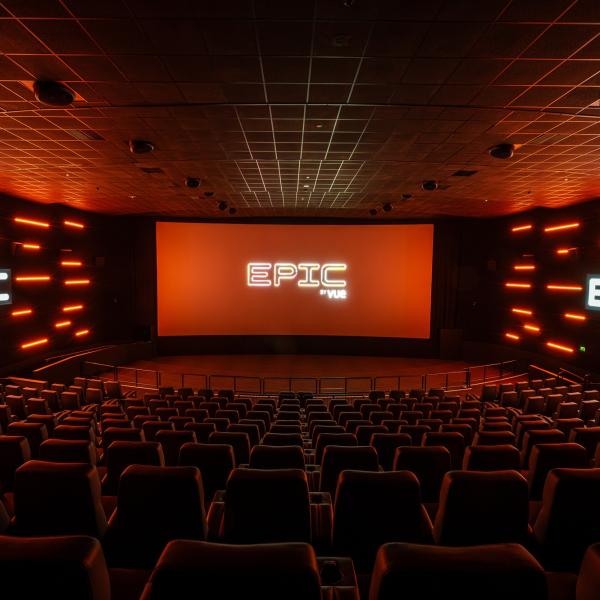 EPIC by Vue cinema auditorium with rows of seats facing a large screen, illuminated by orange lighting.
