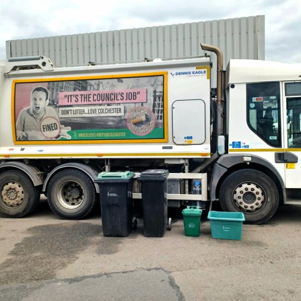 A waste and recycling lorry with wheelie bins and other containers in the foreground