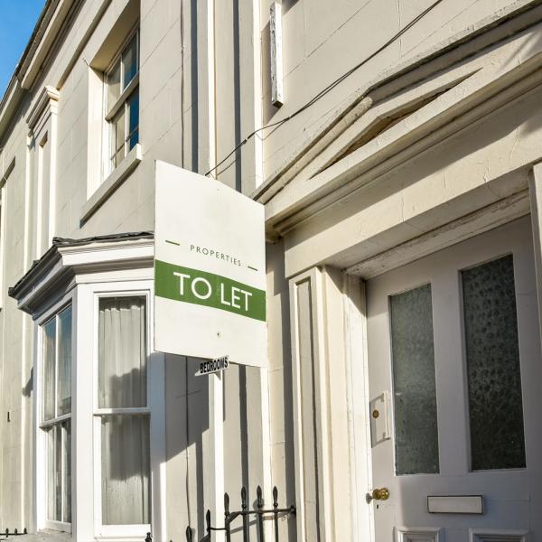 A row of terraced houses with a 'To Let' sign in the foreground